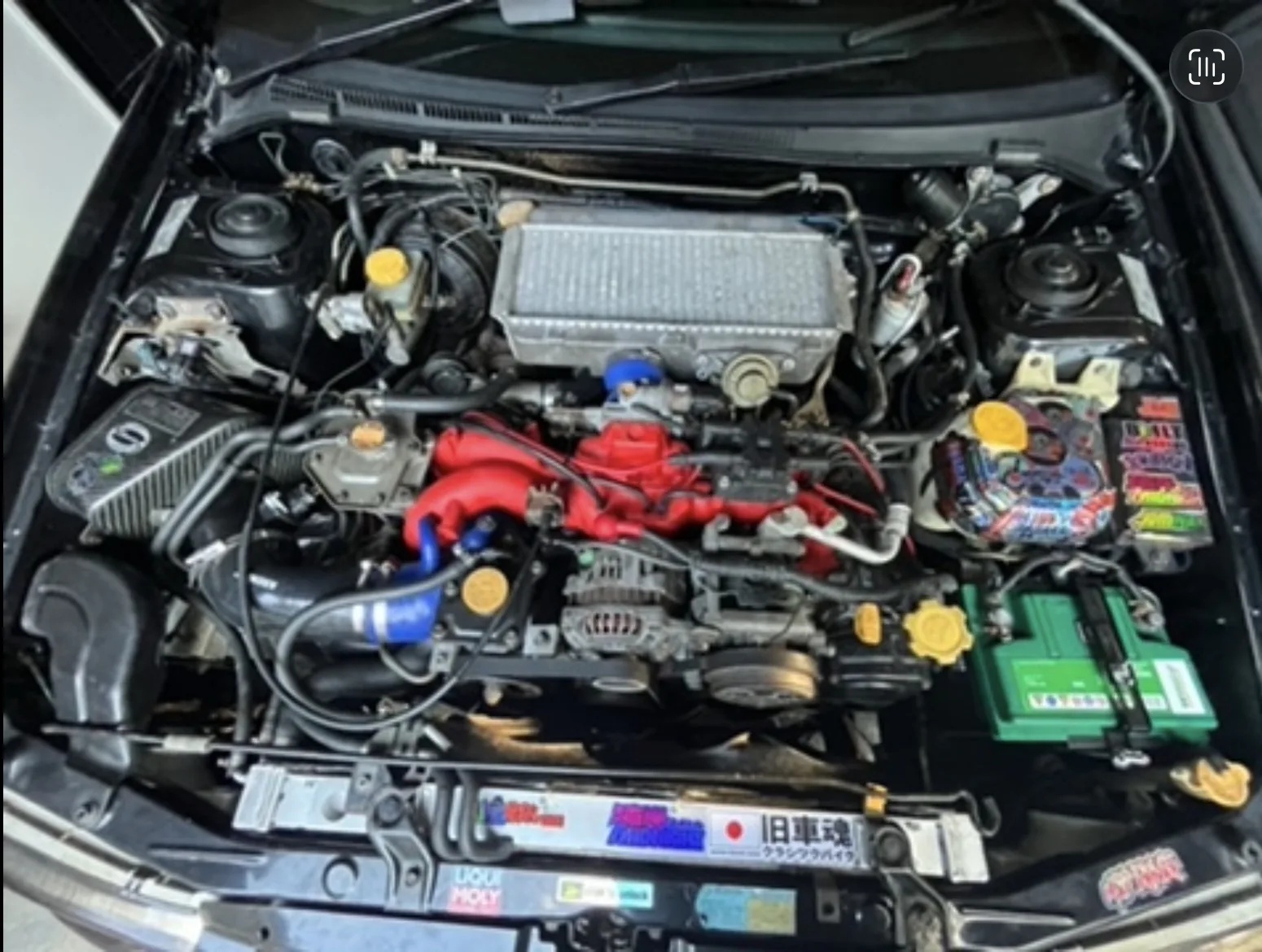 Subaru performance engine bay with red intake manifold and intercooler